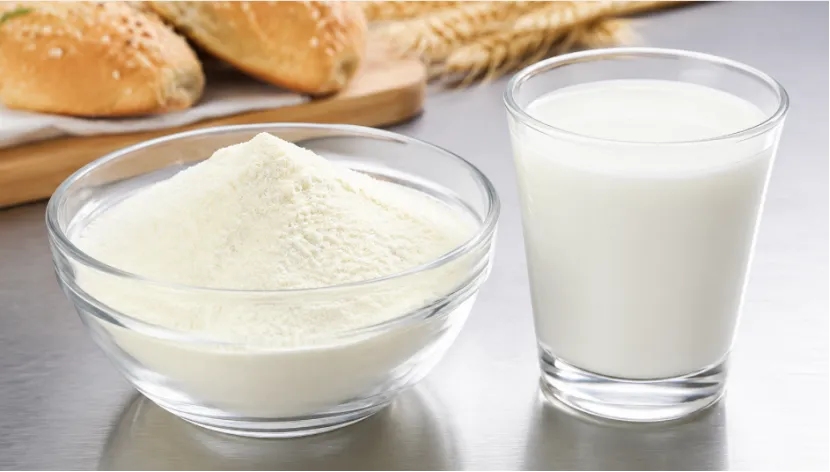 A glass bowl of skim milk powder next to a glass of fresh milk